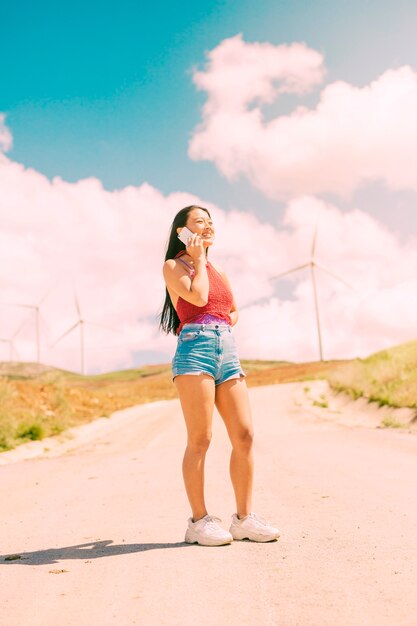 Stylish woman phoning on rural road