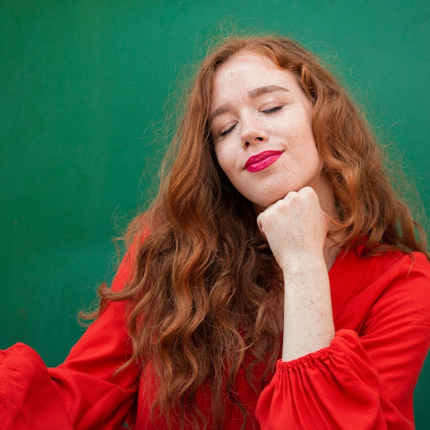 Foto gratuita donna alla moda che posa sul fondo verde