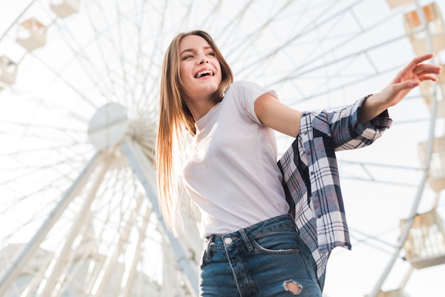 Woman posing near ferris wheel | Photo: Freepik