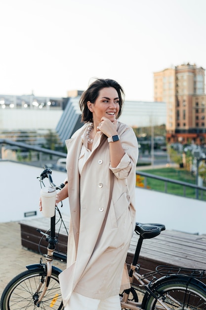 Free photo stylish woman posing with bicycle outdoors