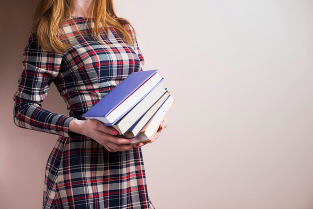 Stylish woman posing with four books