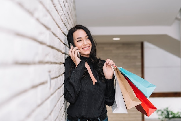 무료 사진 세련 된 여자 쇼핑 및 전화 말하기