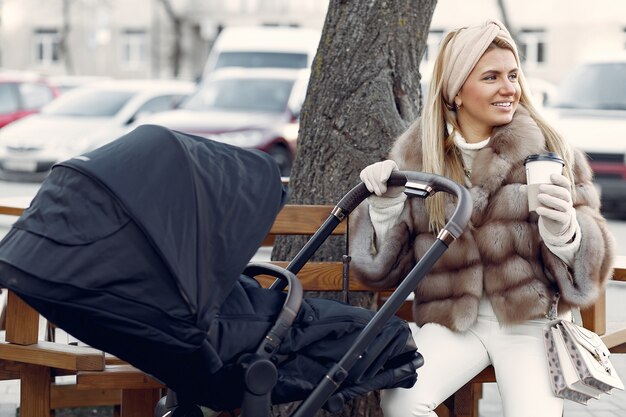 Stylish woman sitting in a city with carriage