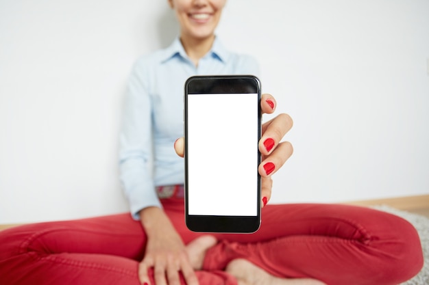 Stylish woman sitting on the floor with smartphone