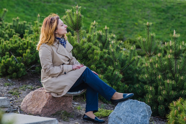 Stylish woman sitting on a rock