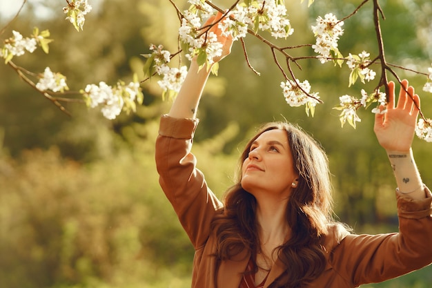 Foto gratuita donna alla moda trascorrere del tempo in un parco di primavera