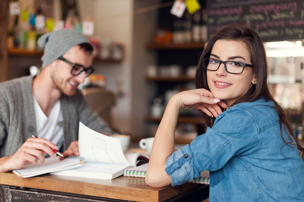 カフェで友達と勉強しているスタイリッシュな女性