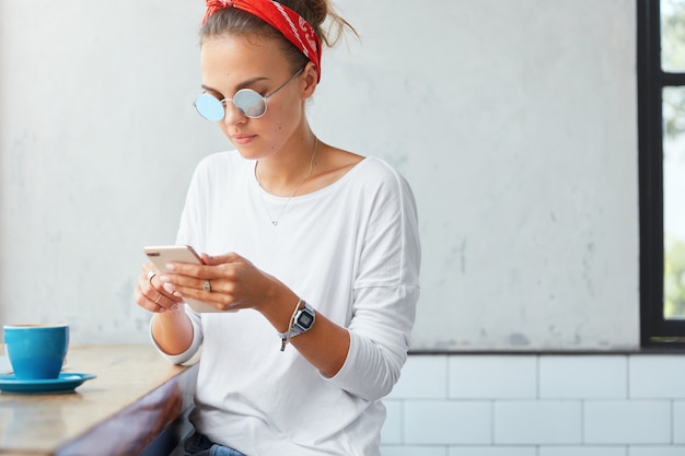 Foto gratuita elegante donna che indossa bandana seduto nella caffetteria