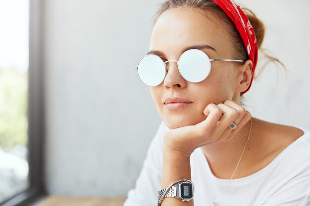 Stylish woman wearing bandana sitting in cafe