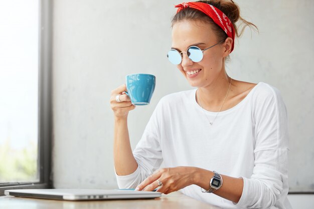 Stylish woman wearing bandana sitting in cafe