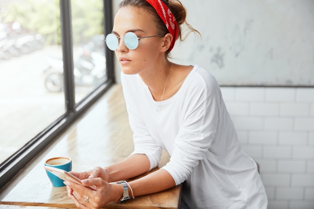 Stylish woman wearing bandana sitting in cafe