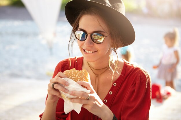 Stylish woman wearing red blouse and big hat