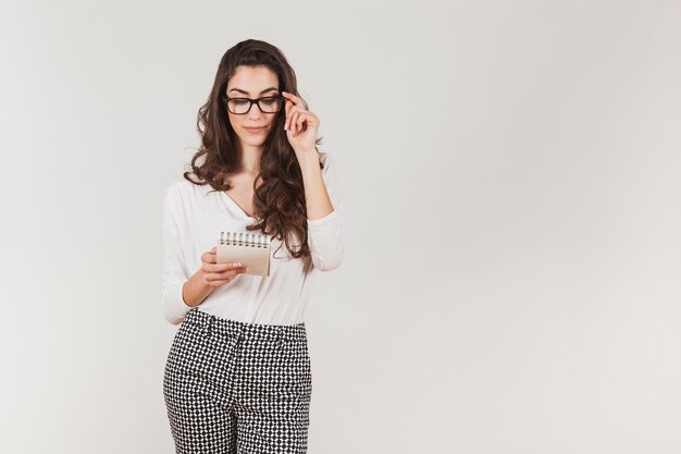 Stylish woman with glasses holding a notebook