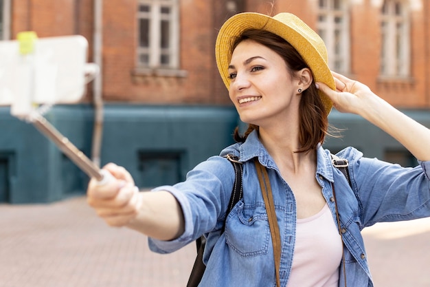 무료 사진 야외에서 selfie를 복용하는 모자와 세련 된 여자