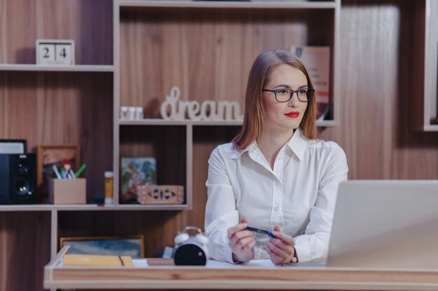 세련 된 여자는 현대 사무실에서 노트북 책상에서 작동