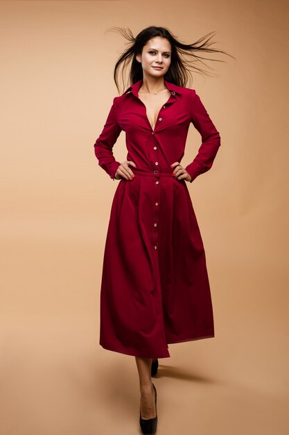 赤いドレスのスタイリッシュな若いブルネットの女性モデル