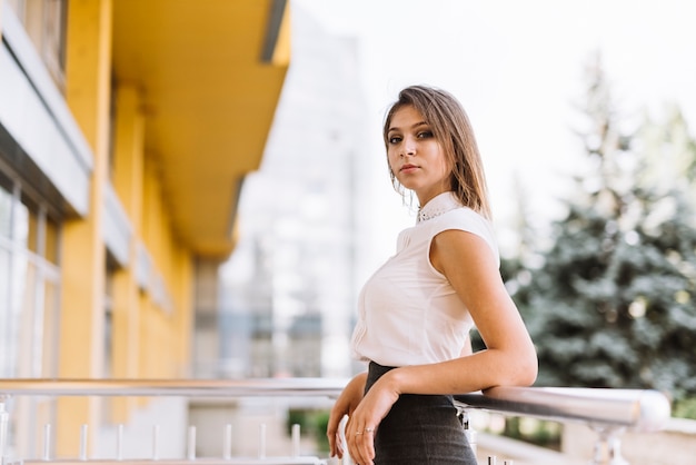 Foto gratuita elegante giovane imprenditrice in piedi nel balcone