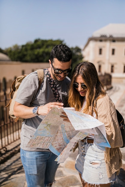 Foto gratuita elegante giovane coppia in vacanza guardando la mappa