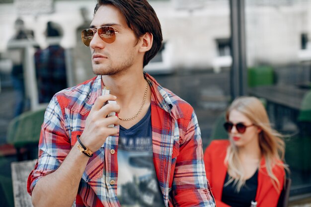 Stylish young couple with vape in a cafe