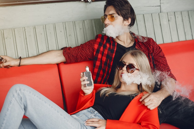 Free photo stylish young couple with vape in a city