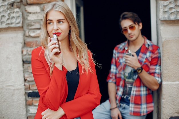 Stylish young couple with vape in a city