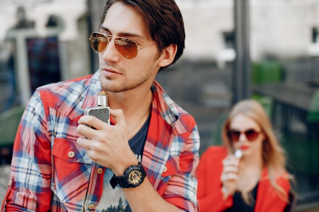 Stylish young couple with vape in a city