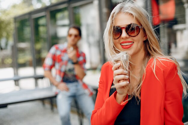 Stylish young couple with vape in a city