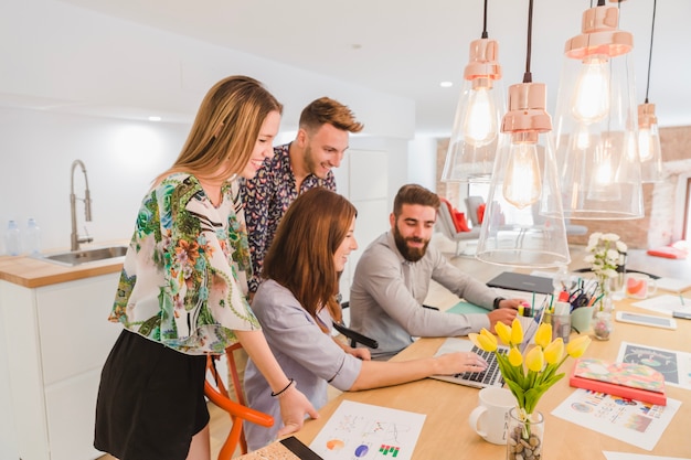 Free photo stylish young coworkers with laptop