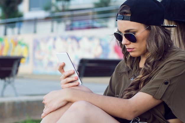 Stylish young female holding smart phone
