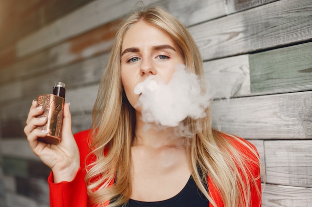 Stylish young girl  in a city with vape