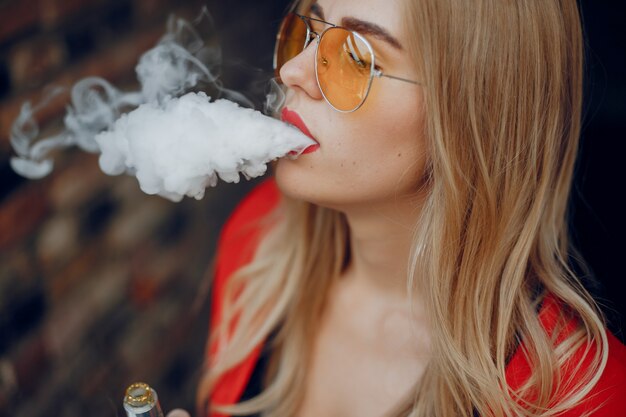 Stylish young girl  in a city with vape