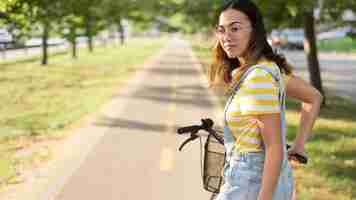 Free photo stylish young girl riding bicycle