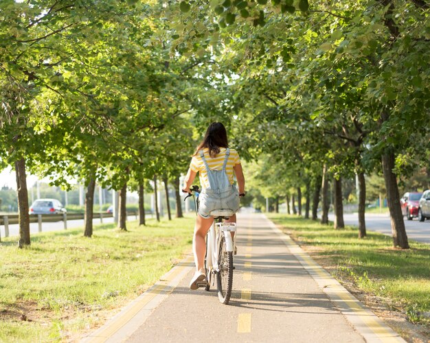 Stylish young girl riding bicycle