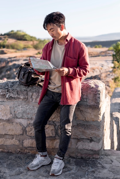 Stylish young man checking map