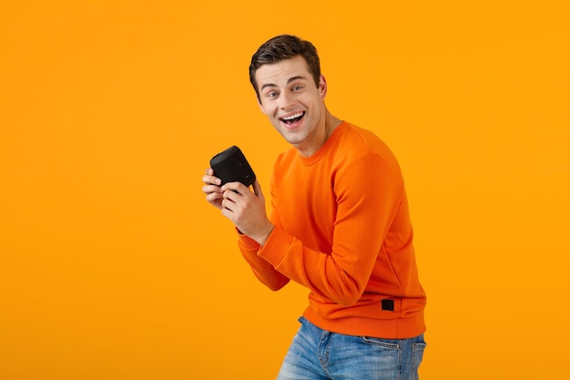 Stylish young man holding wireless speaker