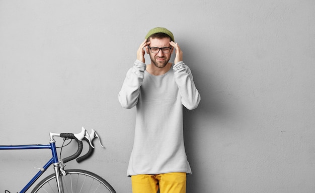 Foto gratuita elegante giovane uomo in piedi vicino alla bicicletta