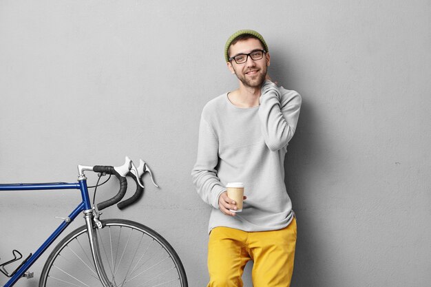 Stylish young man standing near bicycle