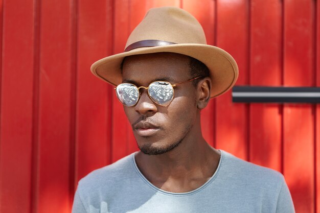 Stylish young man wearing hat and sunglasses