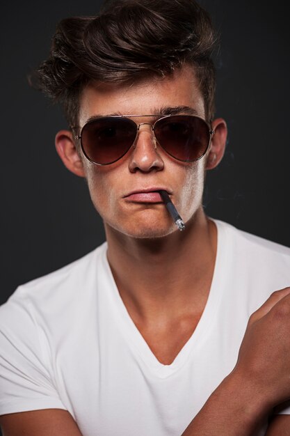 Stylish young man with cigarette between lips