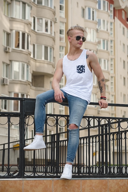 Stylish young man with tattoos and trendy hairdo