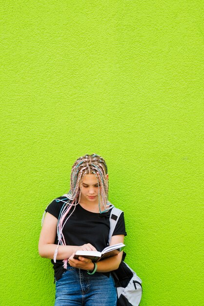 Stylish young student reading book