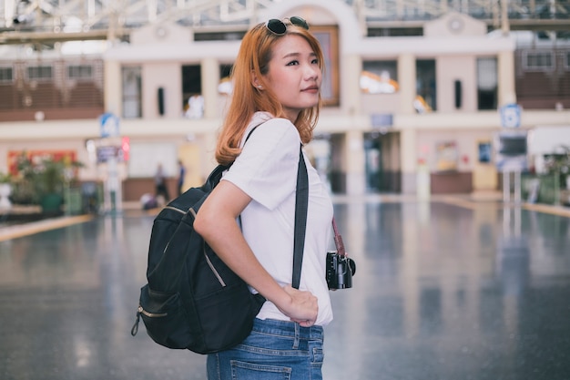 Stylish young traveler with backpack on stations