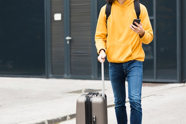 Stylish young traveler with luggage