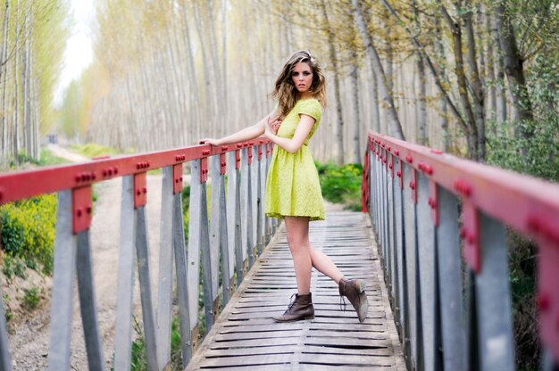 Stylish young woman crossing a bridge