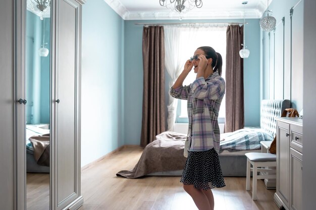 Stylish young woman in front of a mirror in the room gathering