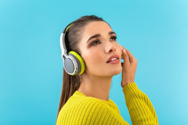 Stylish young woman holding listening to music in headphones