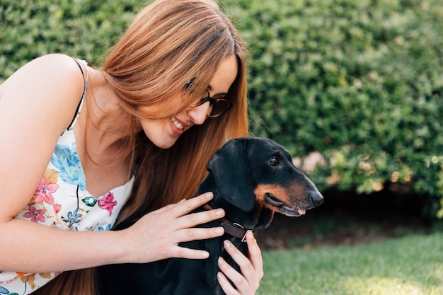 Foto gratuita giovane donna alla moda che ama il suo cane