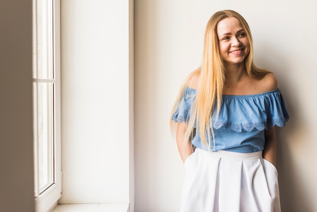 Free photo stylish young woman posing near window