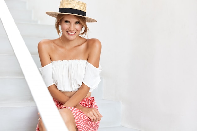 Free photo stylish young woman posing on stairs