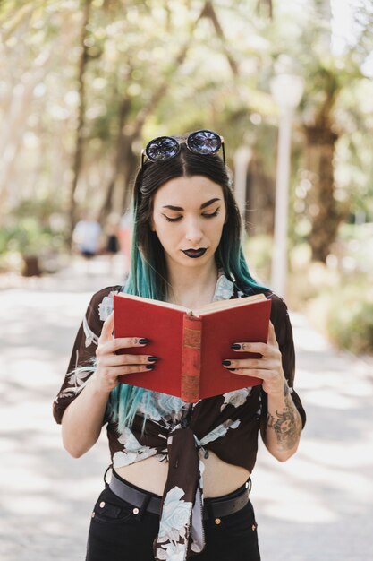 Stylish young woman reading book in the park